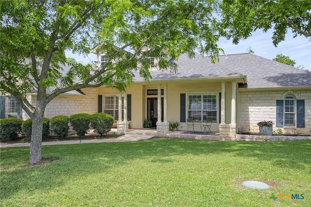 20904 Apache Plum Ln, Pflugerville, TX 78660 - view of front of house with a front yard, a shingled roof, and stone siding