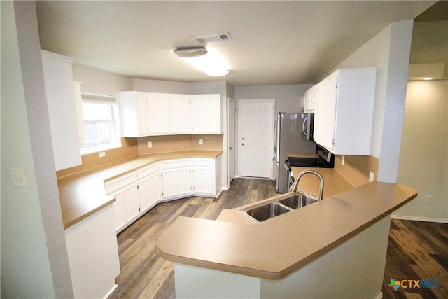 kitchen featuring kitchen peninsula, stove, white cabinetry, and sink