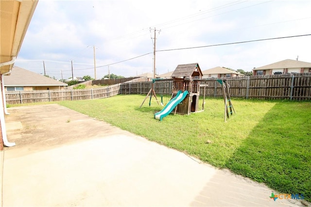 view of play area featuring a lawn and a patio