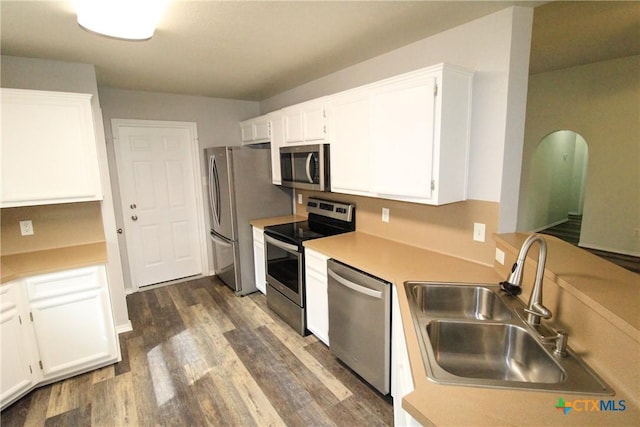 kitchen with dark hardwood / wood-style flooring, white cabinetry, sink, and appliances with stainless steel finishes