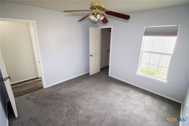 unfurnished bedroom featuring ceiling fan and dark carpet