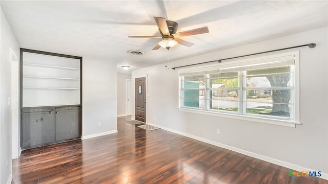 unfurnished bedroom featuring a ceiling fan, visible vents, baseboards, a closet, and dark wood-style floors