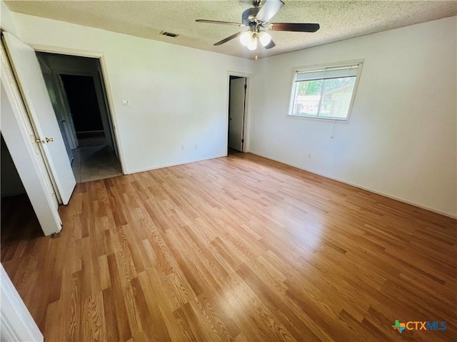 212 Brook St, Seguin, TX 78155 - unfurnished room with light wood-style floors, a textured ceiling, and ceiling fan