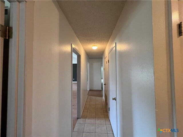 212 Brook St, Seguin, TX 78155 - corridor with light tile patterned floors and a textured ceiling