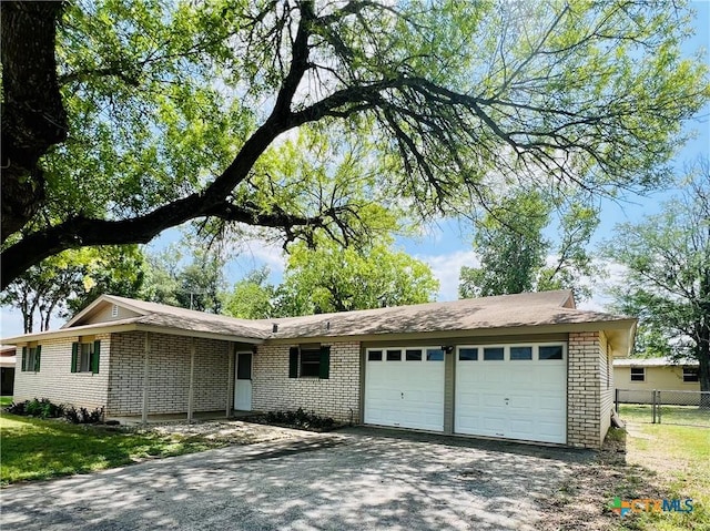 212 Brook St, Seguin, TX 78155 - ranch-style house with brick siding, an attached garage, and driveway