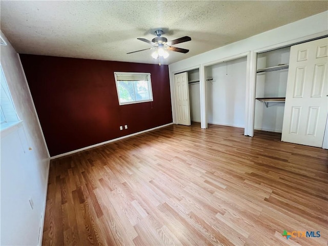 212 Brook St, Seguin, TX 78155 - unfurnished bedroom with light wood-type flooring, a textured ceiling, multiple closets, and ceiling fan