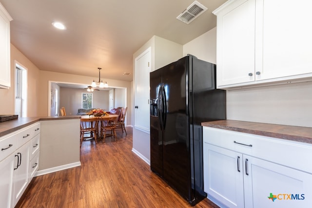 kitchen featuring kitchen peninsula, black refrigerator with ice dispenser, dark wood-type flooring, pendant lighting, and white cabinets