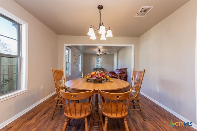 dining area with ceiling fan with notable chandelier, dark hardwood / wood-style flooring, and a healthy amount of sunlight