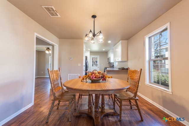 dining space featuring dark hardwood / wood-style floors and a notable chandelier