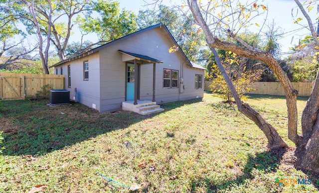 view of front of home featuring central AC unit and a front yard