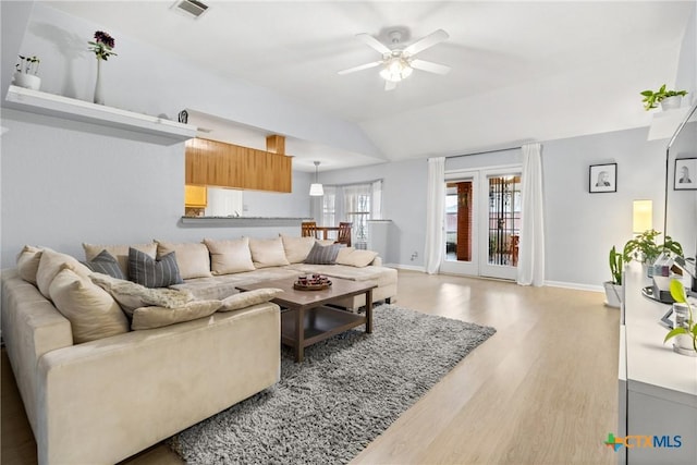 living room with vaulted ceiling, ceiling fan, and light hardwood / wood-style flooring