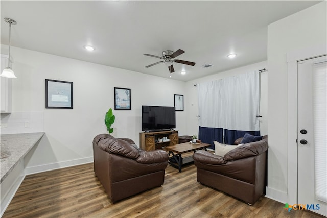 living room with ceiling fan and dark hardwood / wood-style flooring