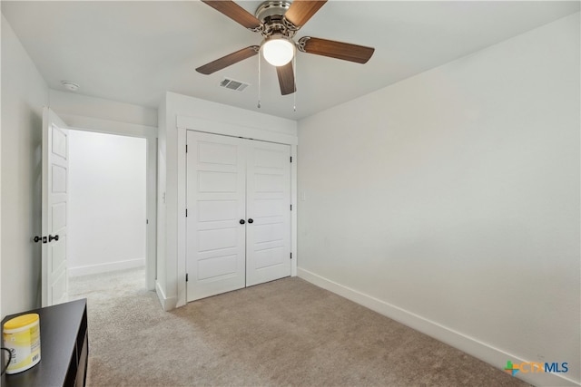 unfurnished bedroom with baseboards, visible vents, a ceiling fan, carpet floors, and a closet