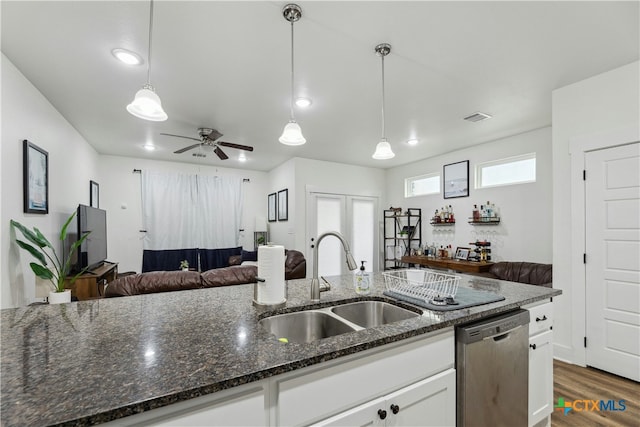 kitchen featuring visible vents, stainless steel dishwasher, open floor plan, white cabinetry, and a sink