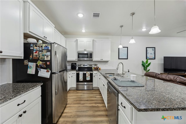 kitchen featuring a sink, wood finished floors, visible vents, white cabinets, and appliances with stainless steel finishes