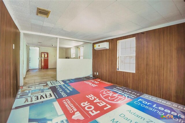 709 Burkett St, Taylor, TX 76574 - entrance foyer with wood walls, an AC wall unit, and healthy amount of natural light