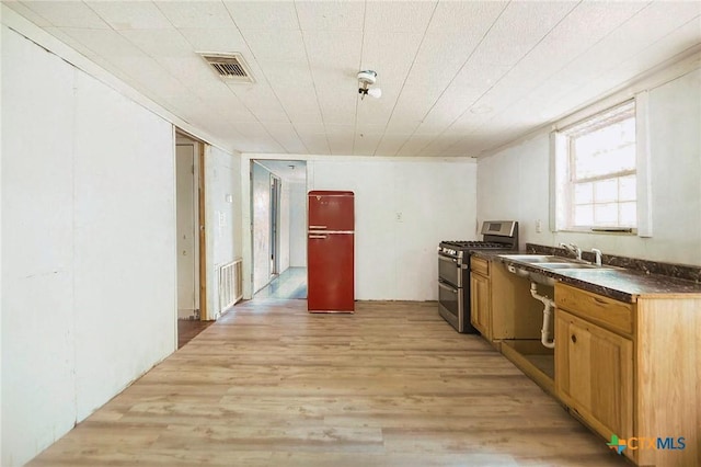 709 Burkett St, Taylor, TX 76574 - kitchen with range with two ovens, a sink, dark countertops, and light wood finished floors