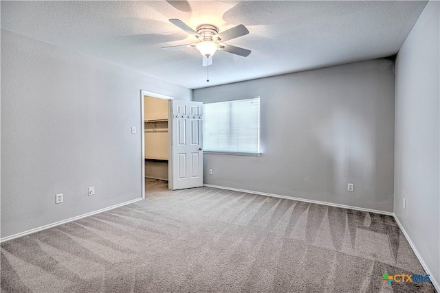 spare room with ceiling fan, light colored carpet, and a textured ceiling