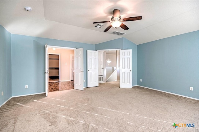 unfurnished bedroom with carpet, ceiling fan, and vaulted ceiling