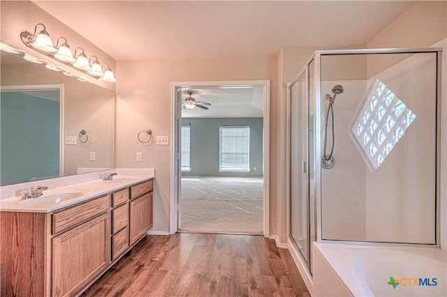 bathroom featuring ceiling fan, vanity, independent shower and bath, and hardwood / wood-style flooring