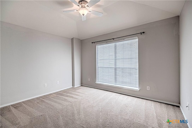 carpeted empty room featuring vaulted ceiling and ceiling fan