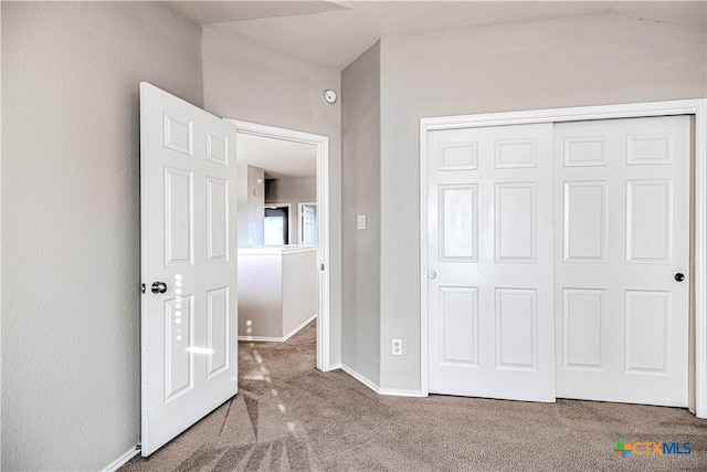 unfurnished bedroom featuring carpet and a closet