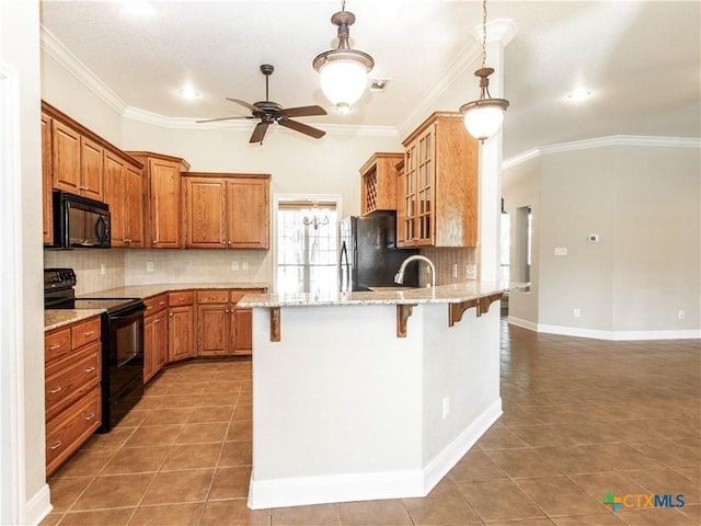 2210 Addax Trl, Harker Heights, TX 76548 - kitchen featuring black appliances, a kitchen bar, ceiling fan, a peninsula, and light tile patterned flooring