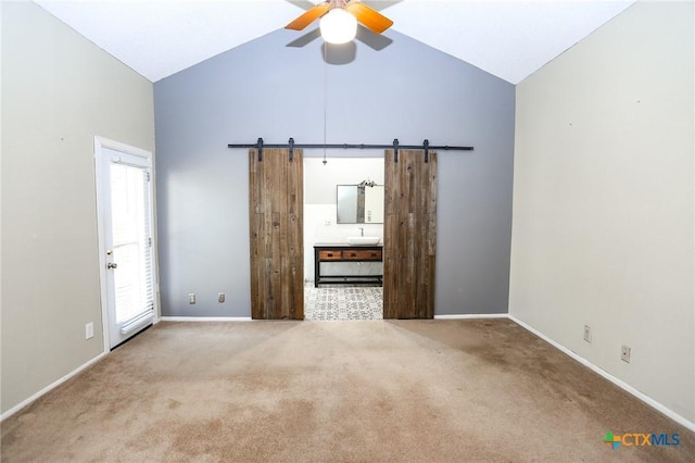 interior space featuring high vaulted ceiling, a barn door, a ceiling fan, baseboards, and carpet flooring