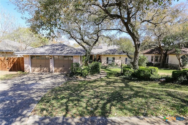 single story home with an attached garage, driveway, fence, and a front yard