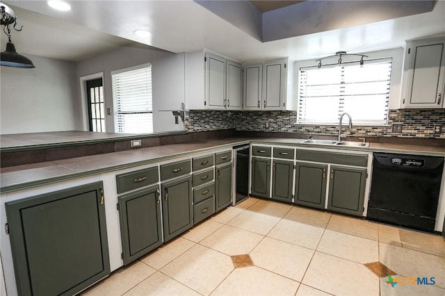kitchen featuring dark countertops, dishwasher, light tile patterned floors, a sink, and decorative backsplash