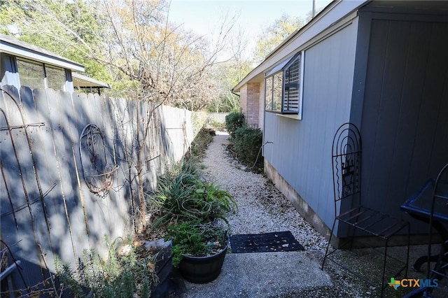 view of side of home featuring fence