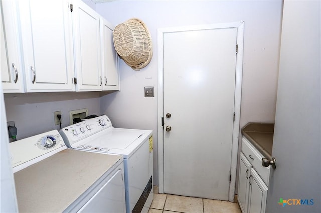 washroom featuring separate washer and dryer, cabinet space, and light tile patterned flooring