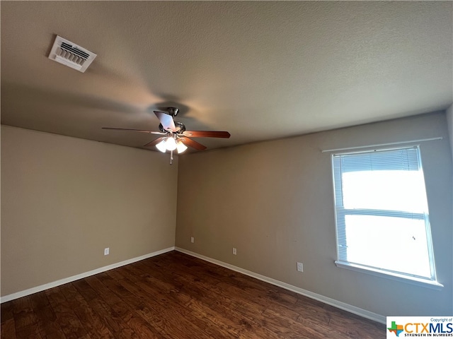 spare room with ceiling fan, a textured ceiling, and dark hardwood / wood-style flooring