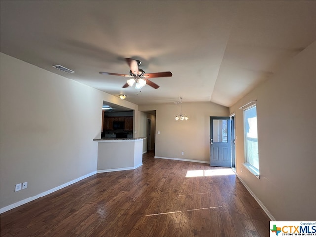 unfurnished living room featuring ceiling fan with notable chandelier, dark wood-type flooring, and vaulted ceiling