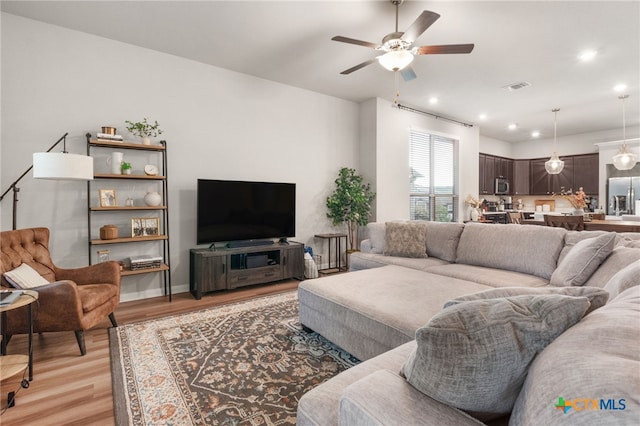 living room with ceiling fan, recessed lighting, light wood-style flooring, and visible vents