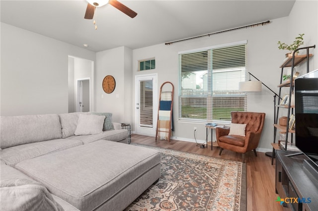 living room with baseboards, ceiling fan, and wood finished floors