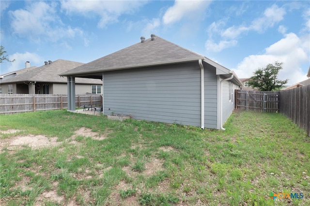 rear view of property with a fenced backyard, a patio, and a lawn