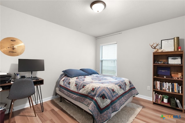 bedroom featuring baseboards and light wood-style flooring