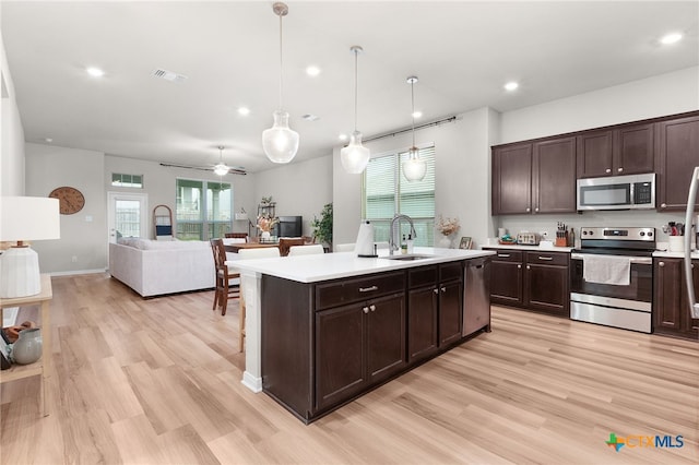 kitchen with visible vents, dark brown cabinets, light countertops, a sink, and stainless steel appliances