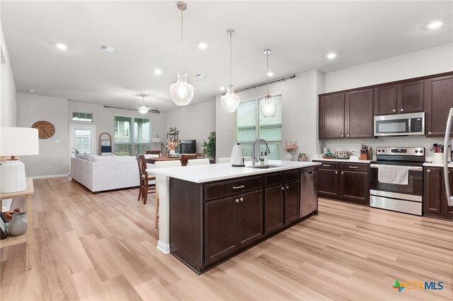 822 Ross Rd, Copperas Cove, TX 76522 - kitchen with stainless steel appliances, light countertops, dark brown cabinetry, recessed lighting, and light wood-style floors