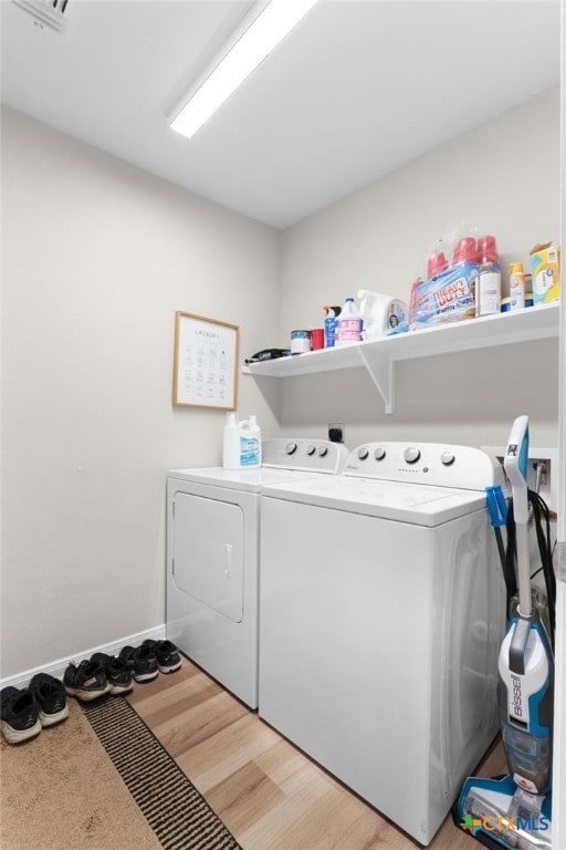 laundry area featuring laundry area, light wood finished floors, and washing machine and dryer