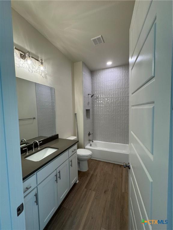 5903 Whippoorwill Rd, Temple, TX 76502 - full bathroom with toilet, vanity, wood finished floors, and shower / bath combination