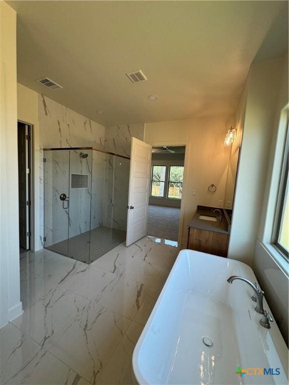 5903 Whippoorwill Rd, Temple, TX 76502 - bathroom with marble tiled floors, a marble finish shower, a soaking tub, and a sink
