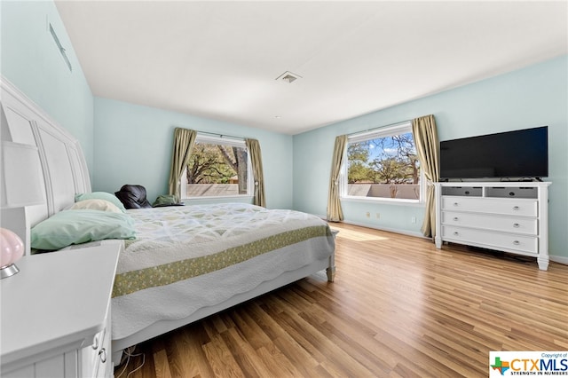 bedroom featuring light wood-type flooring and multiple windows