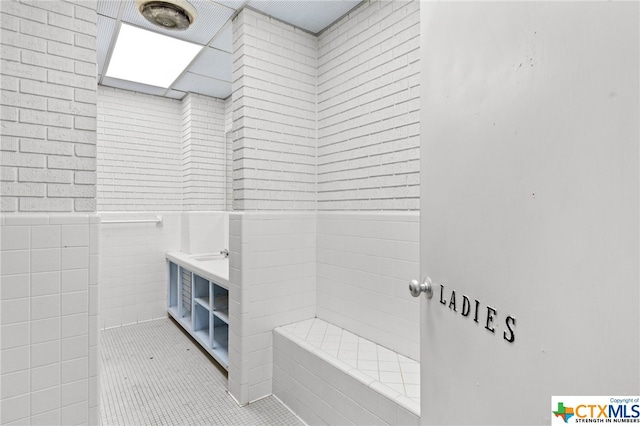 bathroom featuring tile patterned flooring and tile walls