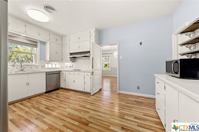 kitchen with white cabinets, appliances with stainless steel finishes, sink, and light hardwood / wood-style flooring