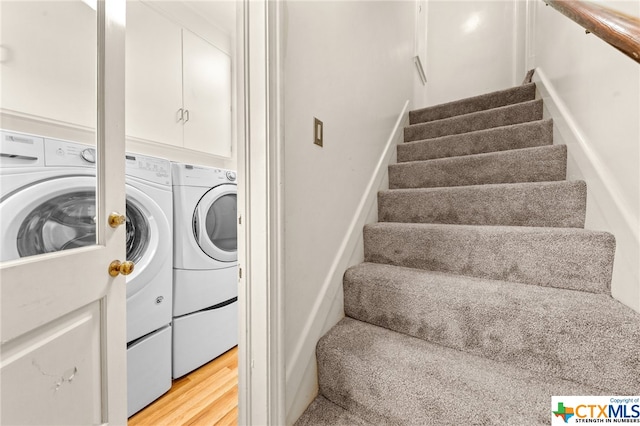 washroom featuring washer and clothes dryer and light hardwood / wood-style floors