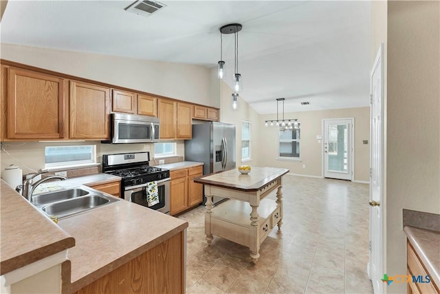 kitchen featuring light countertops, visible vents, appliances with stainless steel finishes, vaulted ceiling, and a sink