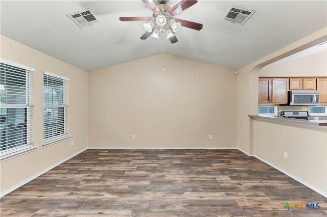 interior space with dark wood finished floors, visible vents, vaulted ceiling, and arched walkways