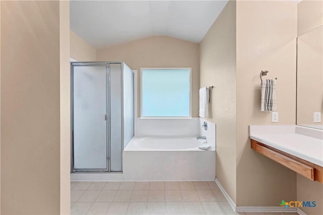 bathroom featuring lofted ceiling, a shower stall, baseboards, and a bath